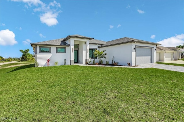 prairie-style house featuring a front lawn, concrete driveway, and a garage