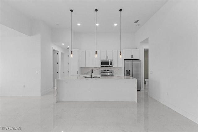 kitchen with white cabinets, stainless steel appliances, a towering ceiling, and a sink