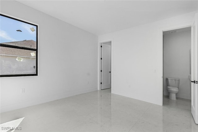 unfurnished room with baseboards and marble finish floor