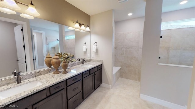 bathroom featuring a sink, plenty of natural light, double vanity, and a walk in shower