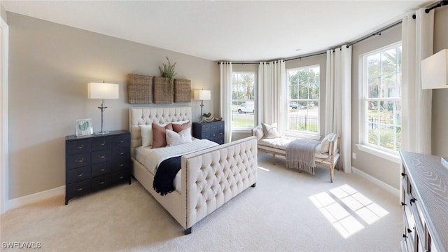 bedroom featuring light carpet and baseboards