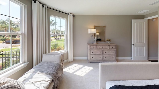 bedroom featuring visible vents, light carpet, and baseboards