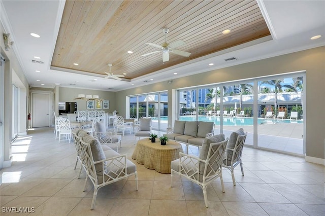 living room with ceiling fan, a tray ceiling, wooden ceiling, and ornamental molding