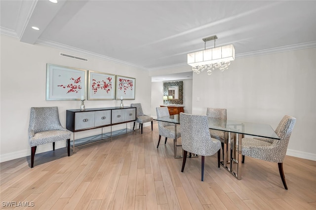 dining space featuring visible vents, baseboards, light wood-style flooring, and crown molding