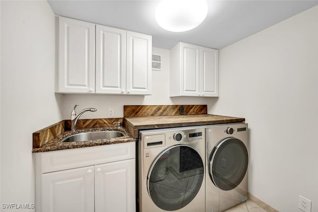 washroom featuring washer and clothes dryer, cabinet space, baseboards, and a sink