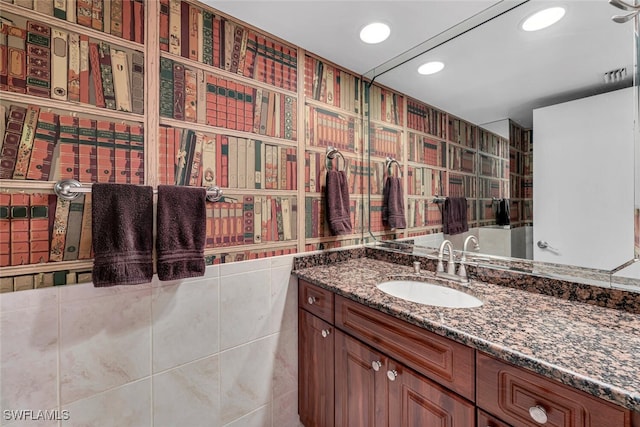 bathroom with recessed lighting, tile walls, and vanity