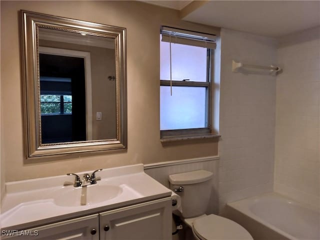 bathroom with vanity, shower / bathing tub combination, toilet, and wainscoting