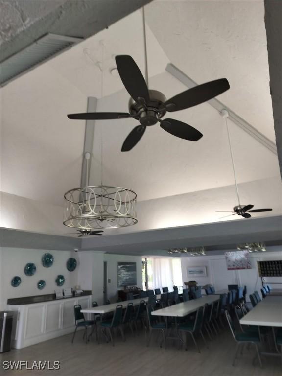 dining space with ceiling fan and high vaulted ceiling