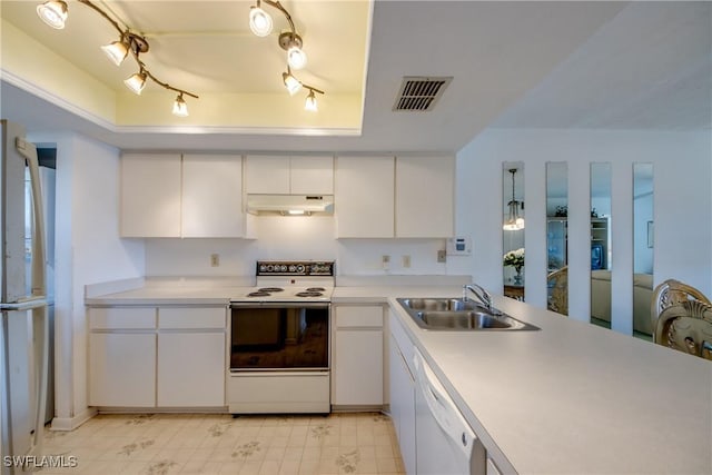 kitchen featuring visible vents, a sink, under cabinet range hood, white appliances, and a raised ceiling