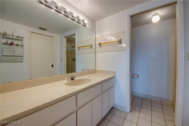 full bathroom featuring tile patterned flooring, vanity, visible vents, and walk in shower