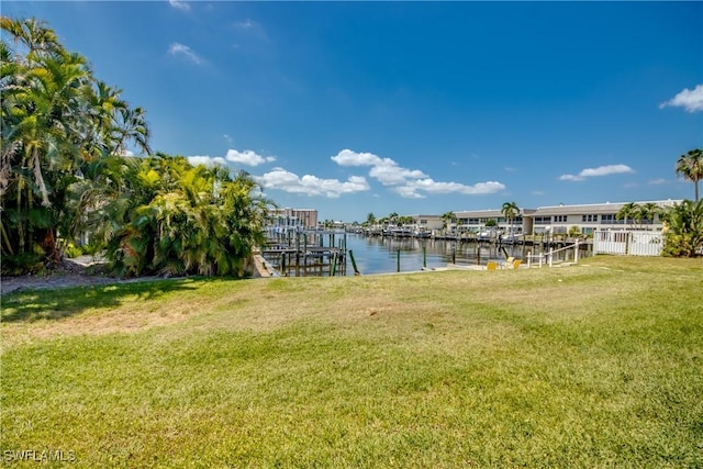 dock area featuring a yard, a water view, and boat lift