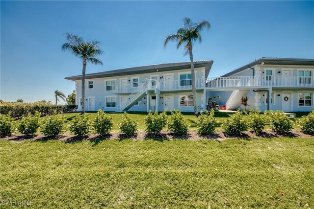 1950 Beach Pkwy Unit 103, Cape Coral, FL 33904 - rear view of property featuring stairway and a yard