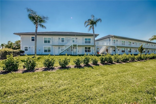 1950 Beach Pkwy Unit 103, Cape Coral, FL 33904 - rear view of property with stairway and a yard
