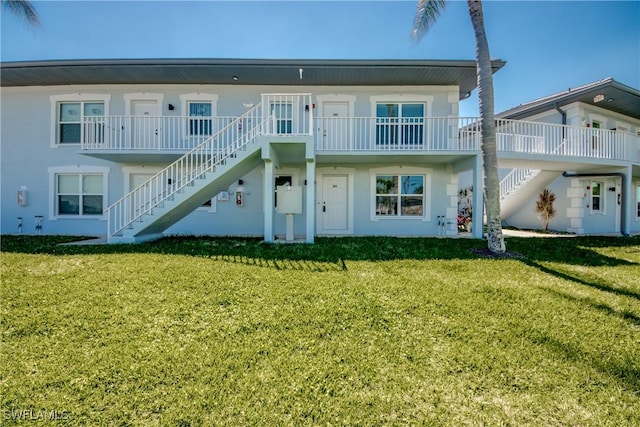 1950 Beach Pkwy Unit 103, Cape Coral, FL 33904 - view of property featuring a front yard, stairway, and stucco siding