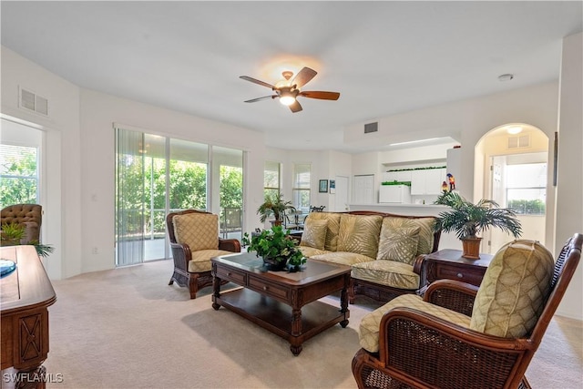 living area with visible vents, light colored carpet, and a healthy amount of sunlight