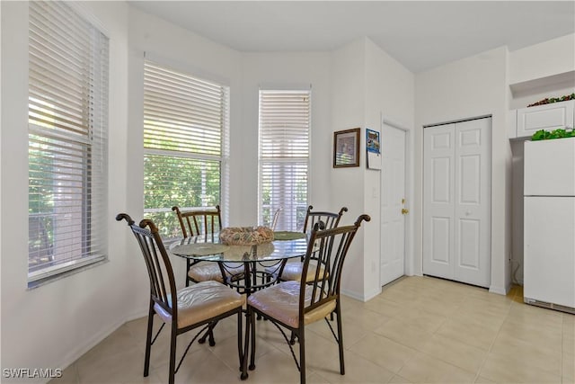 dining space featuring light tile patterned floors and baseboards