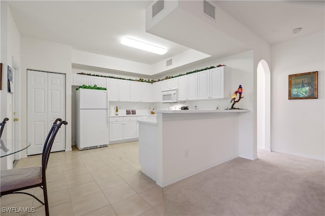 kitchen featuring visible vents, white appliances, arched walkways, a peninsula, and white cabinets