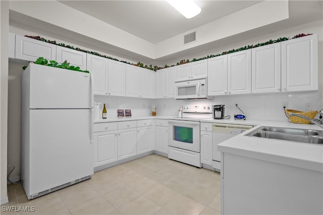 kitchen featuring visible vents, light countertops, white cabinets, white appliances, and a sink