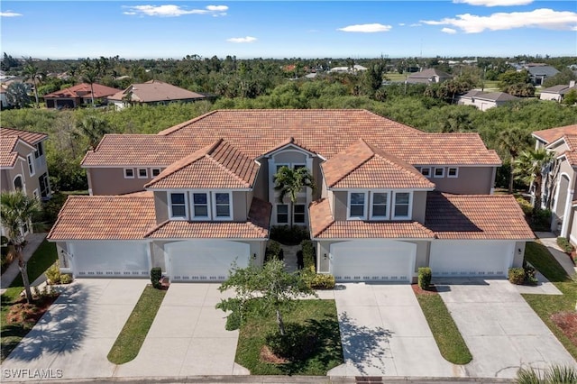 mediterranean / spanish-style home with stucco siding, concrete driveway, and a tiled roof