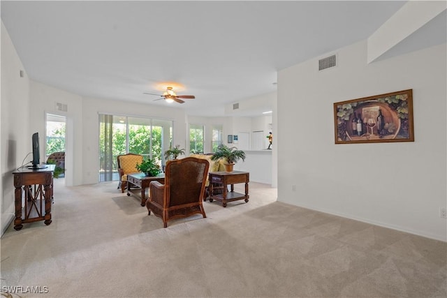 living room with visible vents, light colored carpet, and ceiling fan