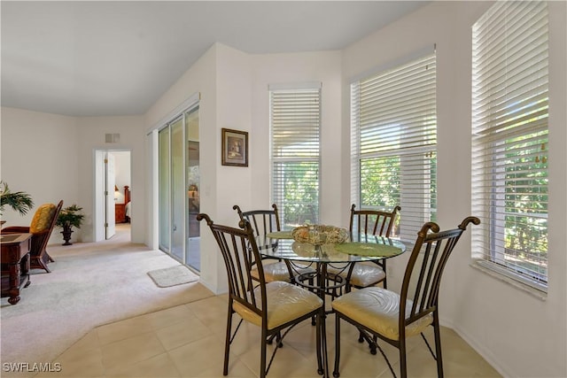 dining room featuring light tile patterned floors, visible vents, and light carpet