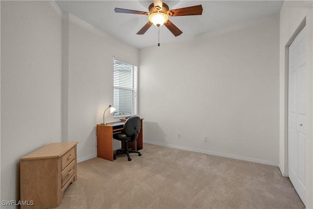 office space with light carpet, ceiling fan, and baseboards