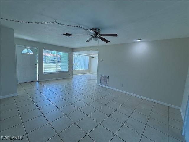 spare room with light tile patterned floors, visible vents, baseboards, and ceiling fan