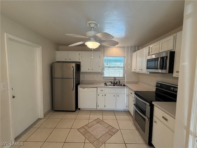 kitchen featuring a sink, white cabinetry, stainless steel appliances, light countertops, and light tile patterned floors