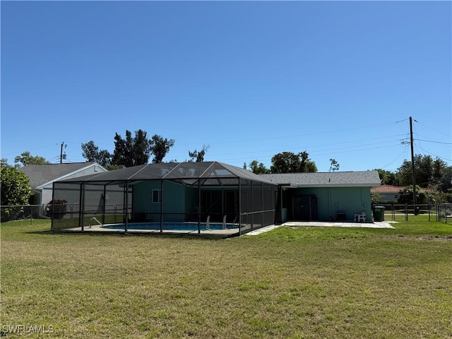 back of property with a lanai, a lawn, and fence