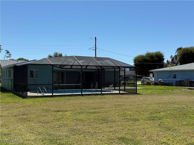 back of property with glass enclosure, a yard, fence, and an outdoor pool