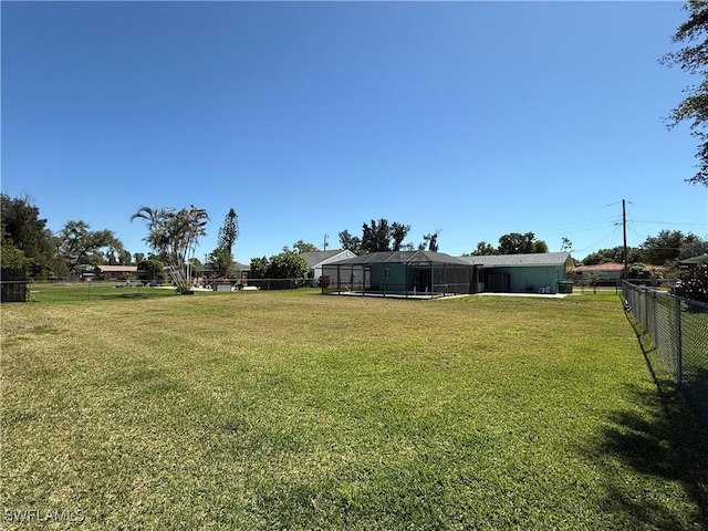 view of yard with a lanai and fence