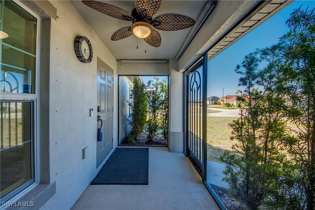 unfurnished sunroom with ceiling fan