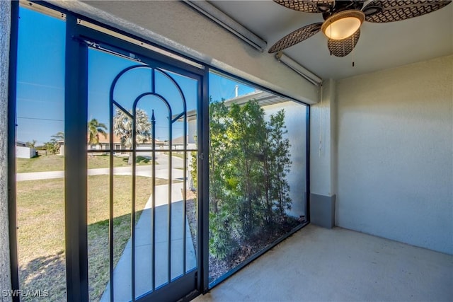 unfurnished sunroom featuring a ceiling fan