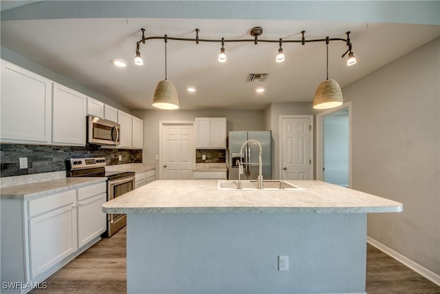 kitchen featuring appliances with stainless steel finishes, white cabinetry, and wood finished floors