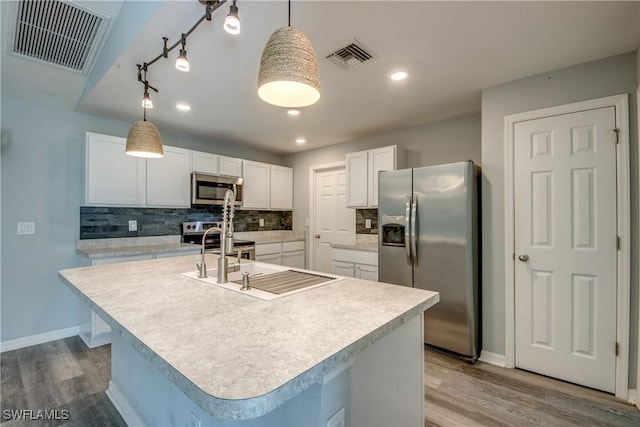 kitchen featuring visible vents, appliances with stainless steel finishes, decorative backsplash, and a sink