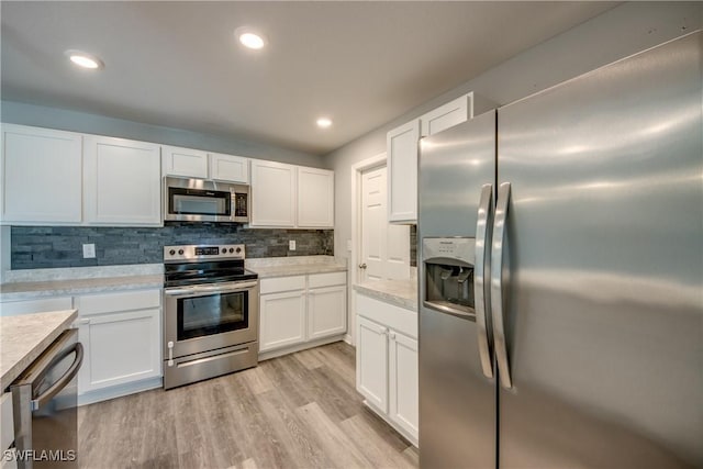 kitchen featuring white cabinetry, light countertops, light wood-style floors, and stainless steel appliances