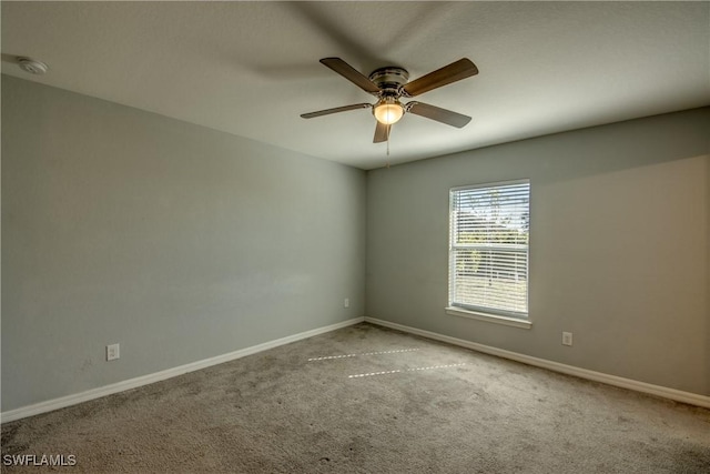 spare room with carpet flooring, a ceiling fan, and baseboards