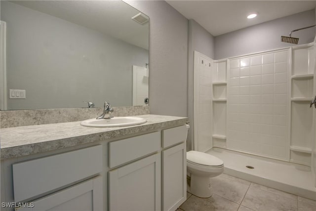 bathroom with visible vents, toilet, tiled shower, tile patterned floors, and vanity