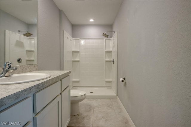 bathroom featuring toilet, tile patterned flooring, a shower, baseboards, and vanity