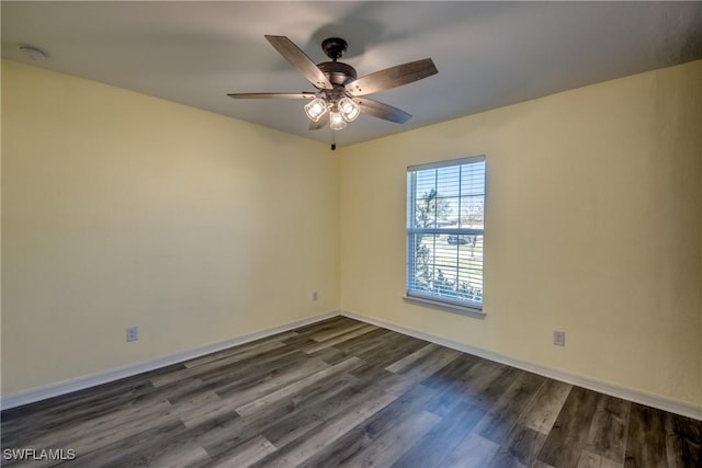 spare room with ceiling fan, baseboards, and dark wood-style flooring