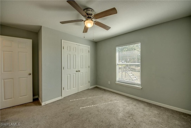 unfurnished bedroom with a ceiling fan, carpet, baseboards, and a closet