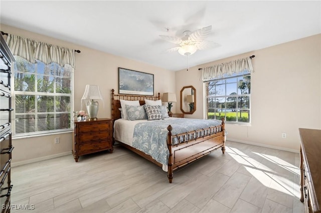 bedroom with baseboards, light wood-style flooring, and a ceiling fan