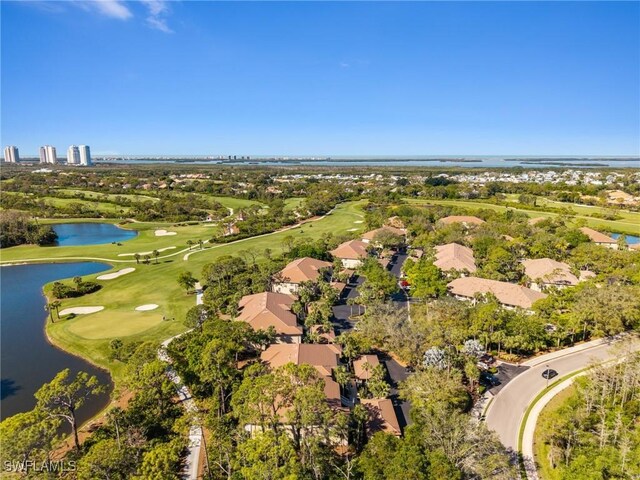 drone / aerial view featuring golf course view and a water view