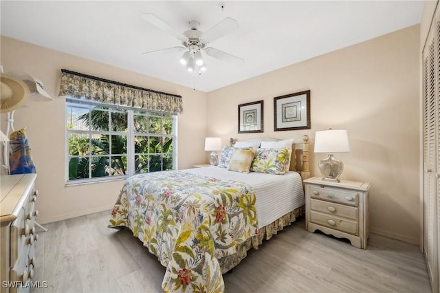 bedroom featuring a ceiling fan, baseboards, and wood finished floors