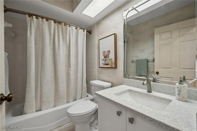 bathroom with toilet, shower / bath combo, and vanity