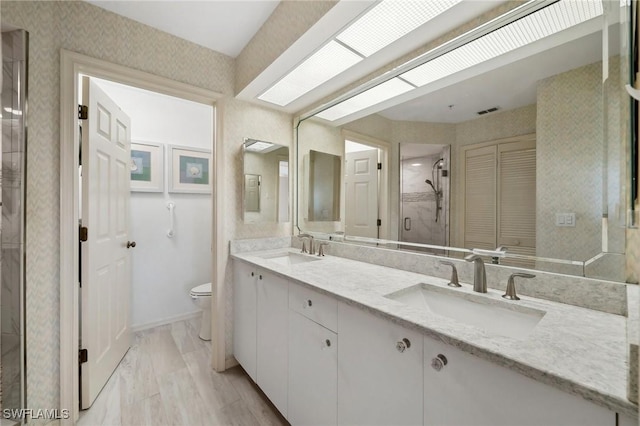 bathroom featuring a sink, toilet, wood finished floors, and double vanity