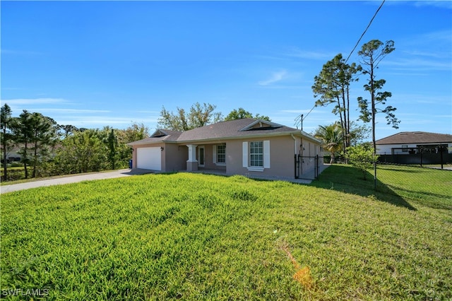 ranch-style home with a front yard, fence, driveway, an attached garage, and stucco siding