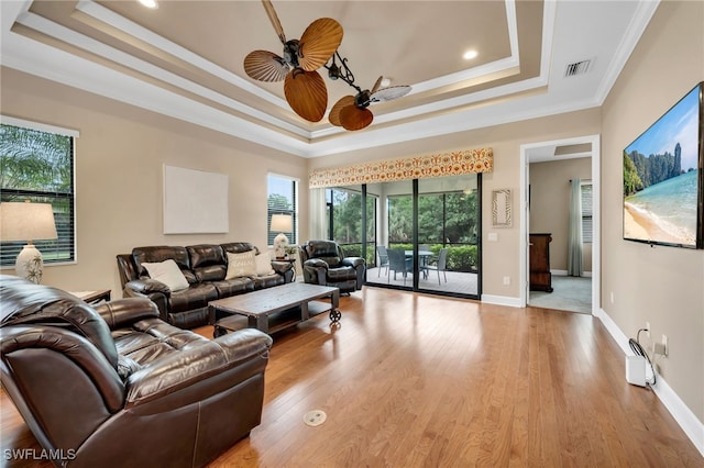 9149 Isla Bella Cir, Bonita Springs, FL 34135 - living room featuring a raised ceiling, ceiling fan, ornamental molding, light wood-style floors, and baseboards