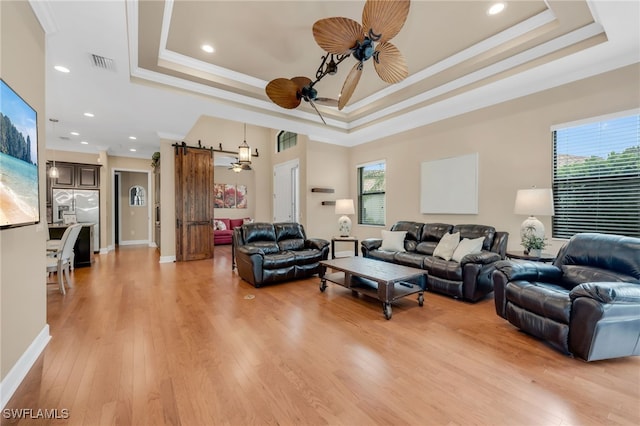 9149 Isla Bella Cir, Bonita Springs, FL 34135 - living area with a raised ceiling, ceiling fan, ornamental molding, a barn door, and recessed lighting