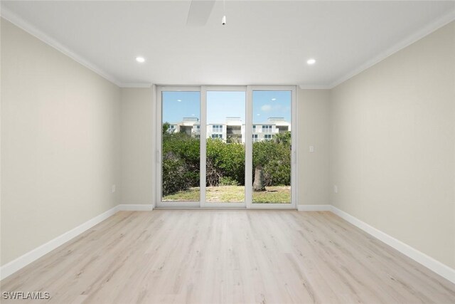 200 Periwinkle Way Unit 132, Sanibel, FL 33957 - unfurnished room featuring floor to ceiling windows, ornamental molding, baseboards, and wood finished floors